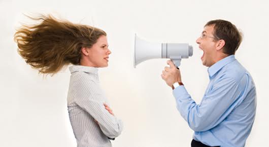 Image of strict boss shouting at businesswoman through loudspeaker so loudly that her hair being blown by strong wind